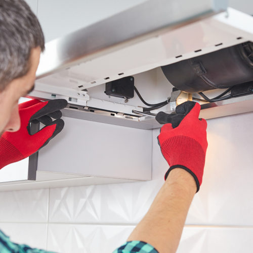 technician-close-up-with-gloves-repairing-house-kitchen-range-hood-fort-collins-co