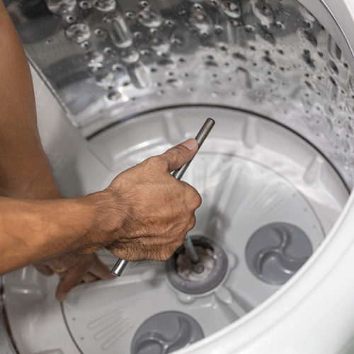 technician-hand-close-up-with-tool-repairing-washing-machine-interiors-fort-collins-co
