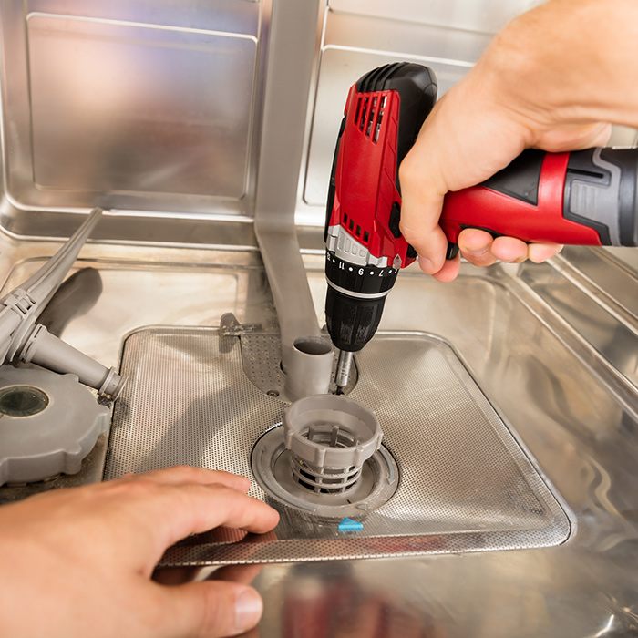 technician-hands-with-drill-close-up-repairing-dishwasher-interiors-fort-collins-co